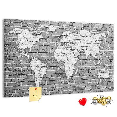 Korktafel mit Motiv Weltkarte an einer Backsteinmauer
