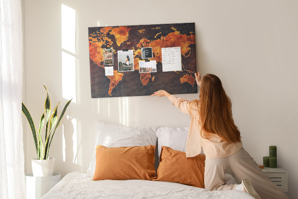 Korktafel mit Motiv einer goldenen Weltkarte auf braunem Hintergrund