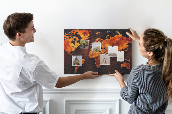 Korktafel mit Motiv einer goldenen Weltkarte auf braunem Hintergrund