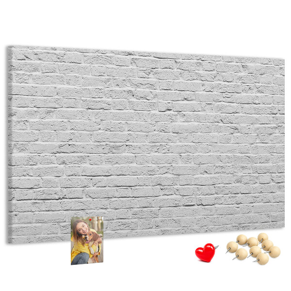 Korktafel mit weißem Backsteinmauer-Motiv und bunten Reißzwecken