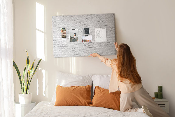 Korktafel mit weißem Backsteinmauer-Motiv und bunten Reißzwecken