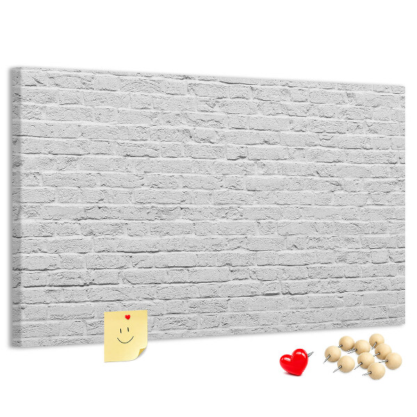 Korktafel mit weißem Backsteinmauer-Motiv und bunten Reißzwecken