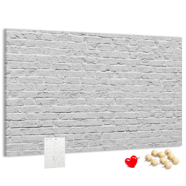 Korktafel mit weißem Backsteinmauer-Motiv und bunten Reißzwecken