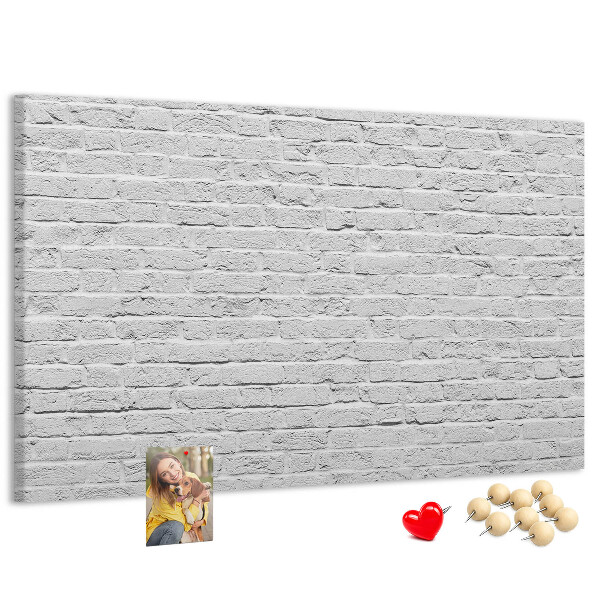 Korktafel mit weißem Backsteinmauer-Motiv und bunten Reißzwecken