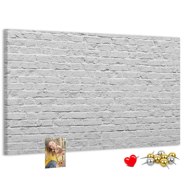 Korktafel mit weißem Backsteinmauer-Motiv und bunten Reißzwecken