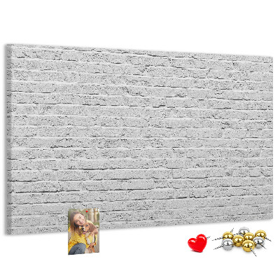 Korktafel mit weißem Backsteinmauer-Motiv und bunten Reißzwecken