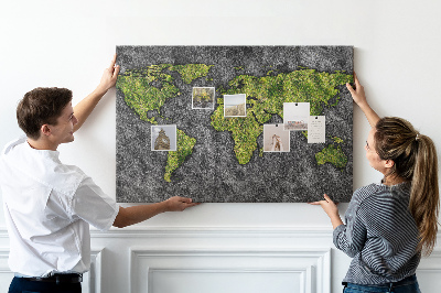 Korktafel mit grüner Weltkarte auf grauem Hintergrund