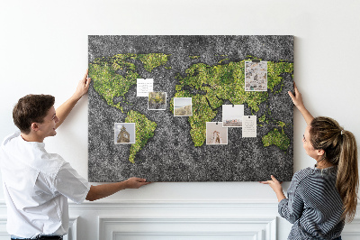Korktafel mit grüner Weltkarte auf grauem Hintergrund